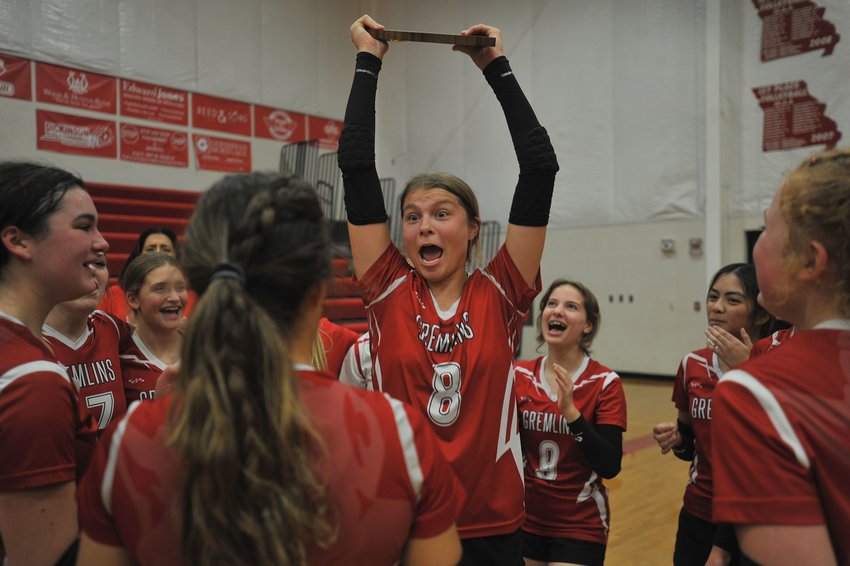 Sacred Heart senior Emma Siron lifts the Class 1 District 5 first-place trophy following Saturday evening&rsquo;s victory over New Haven in Sedalia.