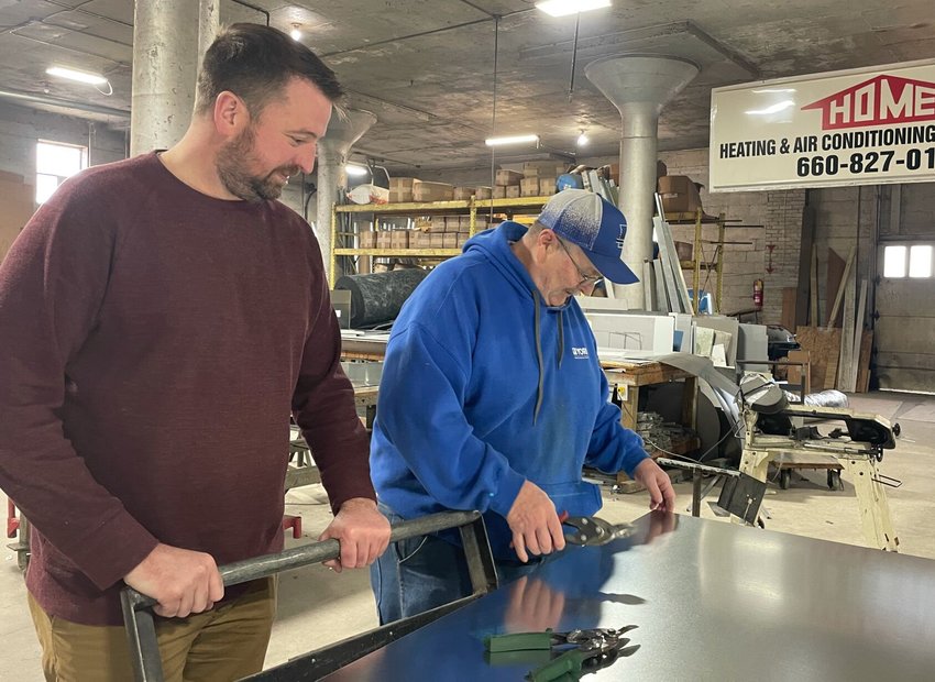 Home Heating and Air co-owner Scott Benbrook and metal fabricator James Anspaugh discuss the specifications for new ductwork produced with Heartland Sheet Metal, 101 E. Main St. Heartland is a division of Home Heating.