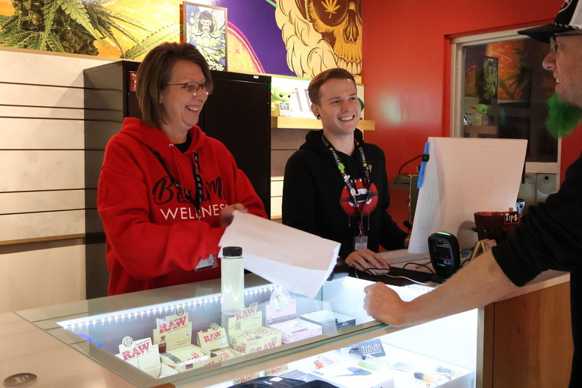 Dana Barkes, Zach Fisher and Ron &ldquo;Panda&rdquo; Coleman share a laugh as they work together to complete orders for patients at Besa Me Wellness on Monday, Jan. 23.