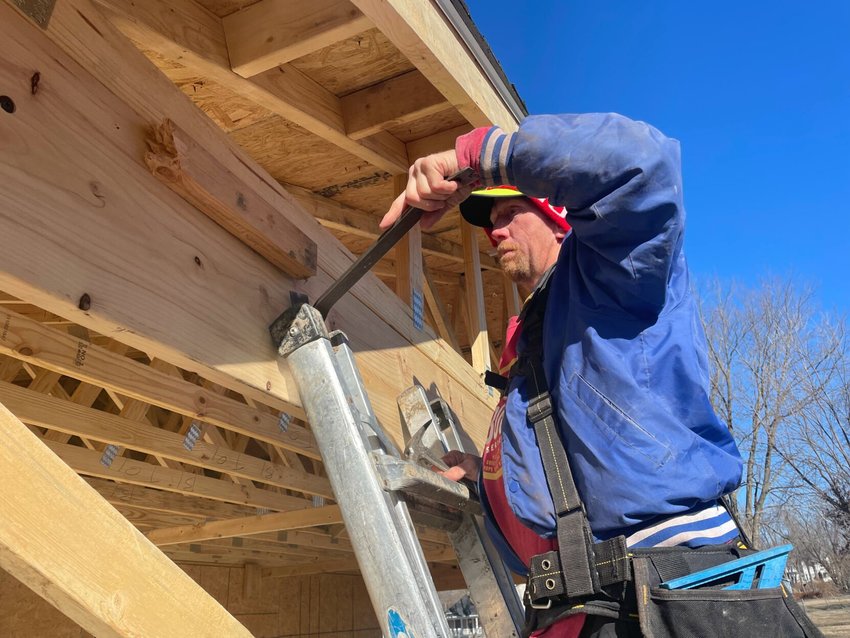 Tony Shepherd with Shep's Construction is teaching carpentry to volunteers working on the Habitat for Humanity home being worked on Saturday in Sedalia.