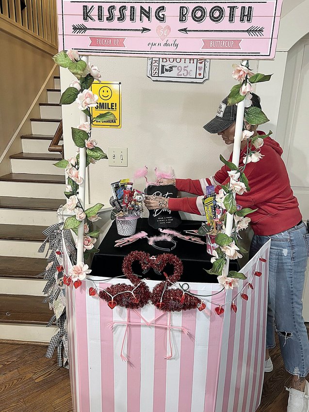 Sarah Rea, the owner of Lolly's Candy Shop, arranges items on a Kissing/Photo Booth at the shop Tuesday afternoon. Lolly's will host the first Downtown Connect meeting Wednesday night, Feb. 15, Sedalia Main Street's quarterly networking event.
