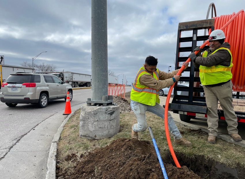 Juan Carlos Naverette Mejia and Irvin Martinez with Open Country gently guide a polymer tube under the intersection of West Broadway Boulevard and South Limit Avenue on Wednesday, Feb. 15. Crews say they are doing well in their job to bring high-speed internet to Sedalia.&nbsp;