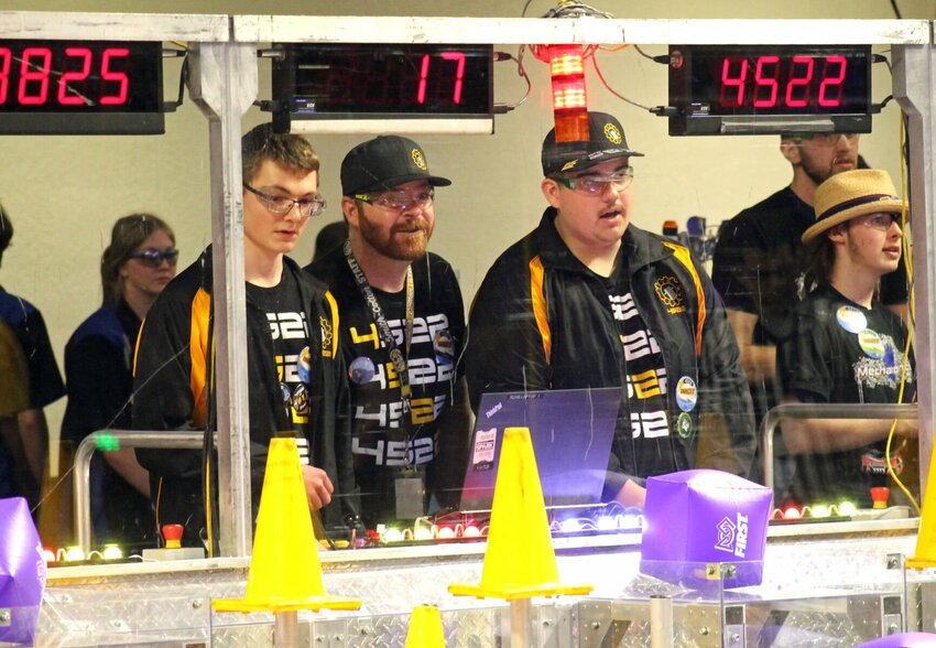 From left, Team SCREAM operator Caleb Ehlers, Coach Michael Wright and driver Cooper Sparks watch as their robot, 4522, works with its two alliance partners during a qualifying match in the Central Missouri Regional FIRST Robotics Competition on Friday afternoon, March 24 at Smith-Cotton High School. The competition continues Saturday, March 25.   Photo by Nicole Cooke | Democrat