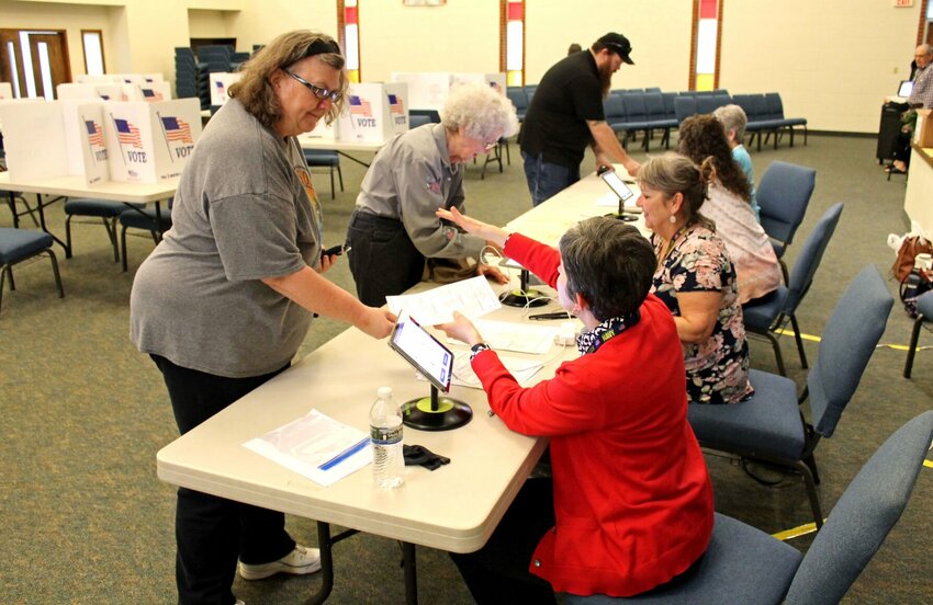 Poll workers check in several Sedalia Ward 3 voters Tuesday evening, April 4 at the New Hope Baptist Church polling location for the municipal election. The workers said they felt they had a steady stream of voters all day.   Photo by Nicole Cooke | Democrat