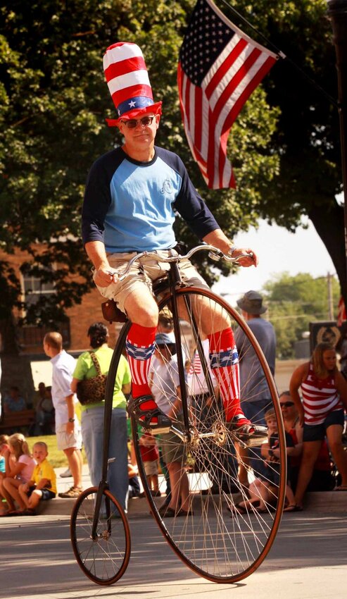 Dr. Douglas Kiburz, an orthopedic surgeon at Bothwell Orthopedics &amp;amp; Sports Medicine, rides an 1880 high wheel bike during a Fourth of July parade in downtown Sedalia.