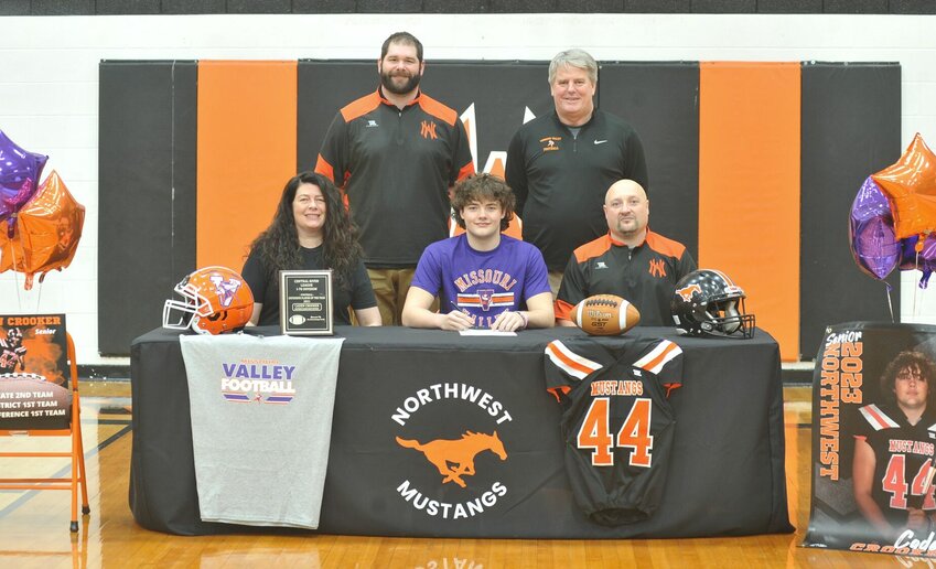 Seated next to parents Rachelle Rogers (front, left) and Caleb Crooker, and backed by Northwest assistant Tim Barnes (back, left) and Missouri Valley College head coach Paul Troth, Caden Crooker's signing with MVC to play football was commemorated at a ceremony Thursday in Hughesville.   PhotoCredit: Photo by Bryan Everson | Democrat