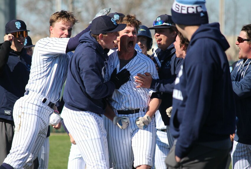 Teammates surround State Fair Community College infielder Conlan Downey after his walk-off hit that drove in two teammates to win Tuesday's game at Liberty Park Stadium.   PhotoCredit: Photo by Bryan Everson | Democrat