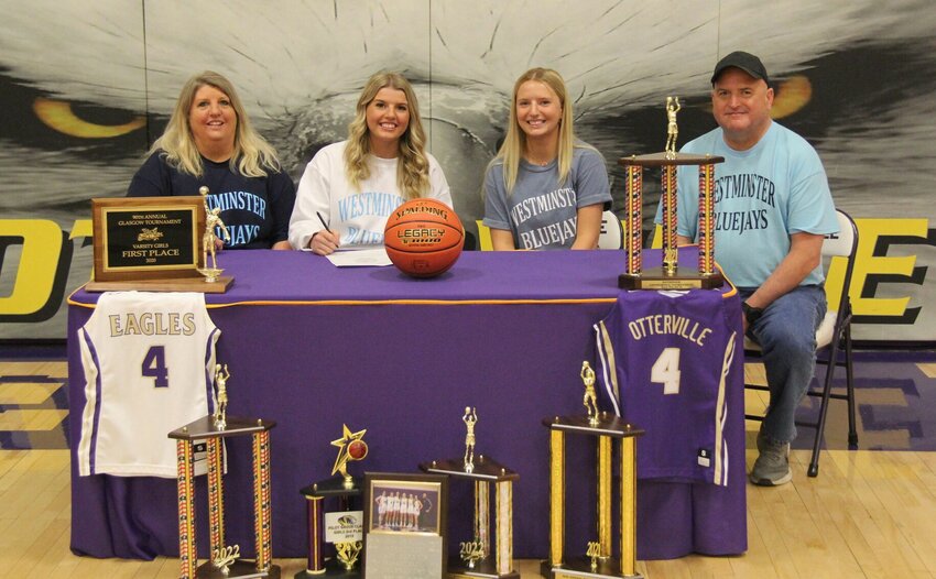 Pictured with her sister Carrie to her right, and with parents Steve and Christi, Katie McKinney commemorates her signing with Westminster College Tuesday morning at Otterville High School.   PhotoCredit: Photo courtesy of Otterville Eagles