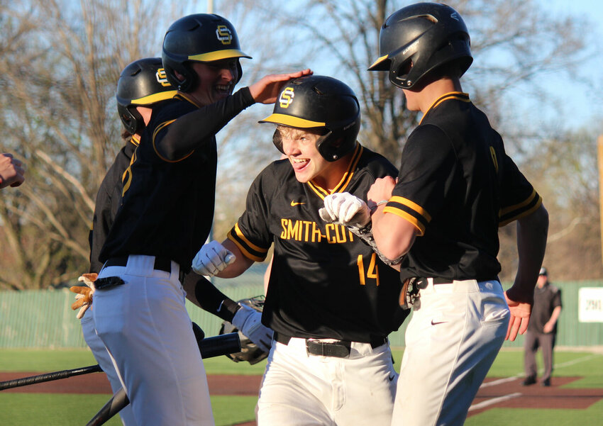 Teammates surround Smith-Cotton freshman Kendall Hagedorn after he crossed the plate and drove in two other runs in a 9-8 victory over Battle at Liberty Park Stadium on Friday evening.   PhotoCredit: Photo by Bryan Everson | Democrat