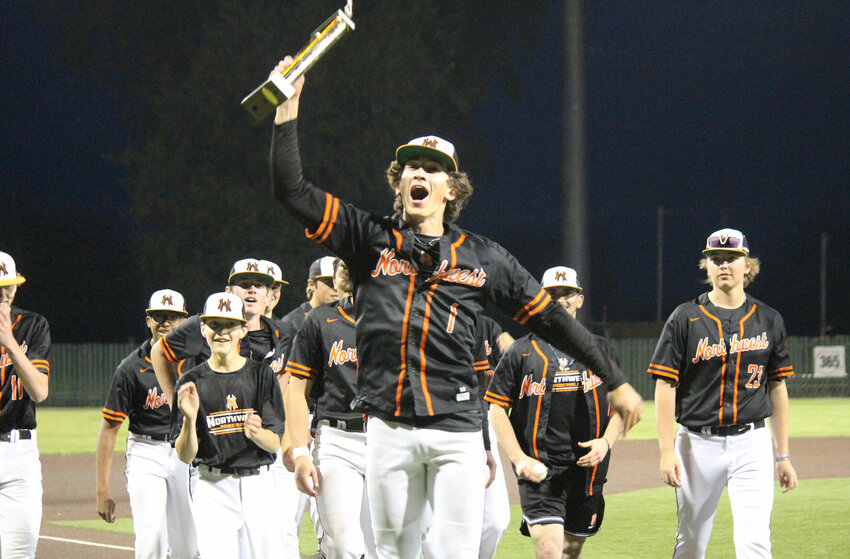 Northwest's Gavin Killion runs towards Mustangs supporters after being awarded the Kaysinger Baseball Tournament Championship trophy.   PhotoCredit: Photo by Bryan Everson | Democrat