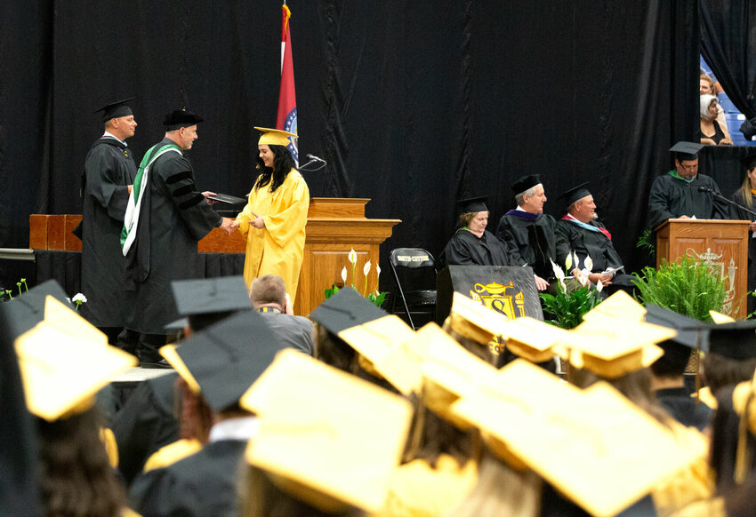 Surrounded by fellow Smith-Cotton students, a new graduate shakes hands with Sedalia School District 200 Superintendent Todd Fraley during the commencement ceremony Saturday evening, May 20 at the Mathewson Exhibition Center on the Missouri State Fairgrounds.   Photo by Nicole Cooke | Democrat