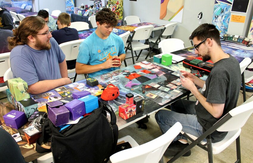 From left, Cordale Singleton, of Sedalia, Luke Bolton, of Knob Noster, and Josh Keller, of Sedalia, play Magic: The Gathering on a recent Friday night at Forever 10 Gaming. The local business is celebrating 10 years.   Photo by Nicole Cooke | Democrat