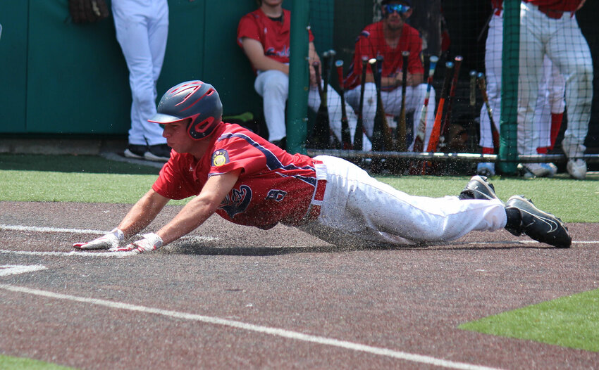Rock Azarro slides safely into home plate for a run as part of Sunday&rsquo;s Sedalia Travelers doubleheader against Oak Grove, which resulted in a win and a loss each.   PhotoCredit: Photo by Bryan Everson | Democrat