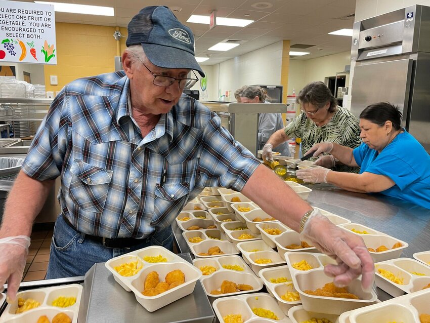 Richard Bishop, Sarah Bishop and Josephine Scribner pack lunches for the Summer Food Service Program on Wednesday, June 21 in the kitchen at Smith-Cotton Junior High School.   Photo by Chris Howell | Democrat