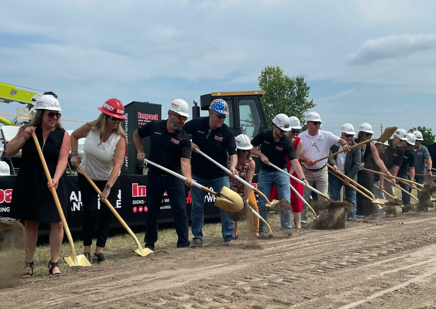 Impact Signs President and CEO David Goodson, wearing his father's patriotic helmet, family, employees and valued guests broke ground Friday morning, June 30 on the company's new headquarters at 810 Curry Drive in Sedalia.   Photo by Chris Howell | Democrat