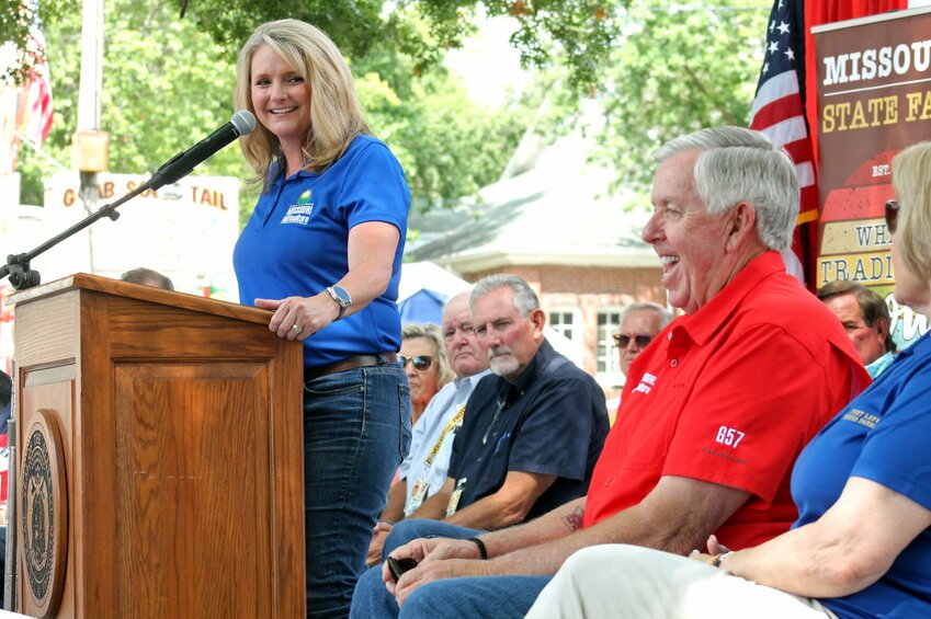 Missouri Director of Agriculture Chris Chinn looks at Gov. Mike Parson as they both laugh during her remarks at the Opening Day Ceremony on Thursday, Aug. 10 on the Missouri State Fairgrounds.   Photo by Nicole Cooke | Democrat