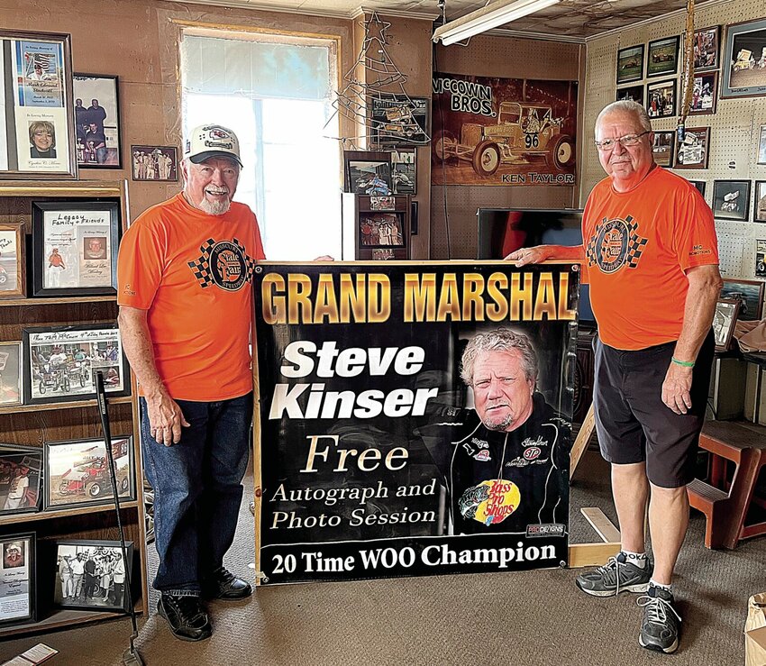 Larry McCown, right, the promoter of the Missouri State Fair Championship on the State Fair Speedway, stands with Tom McCown on Wednesday, Aug. 16. The men are standing by a previous poster of racing great Steve Kinser. Kinser's son Craig Kinser will compete in the Championship on Sunday night, Aug. 20 at the Missouri State Fair.   Photo by Faith Bemiss | Democrat&nbsp;