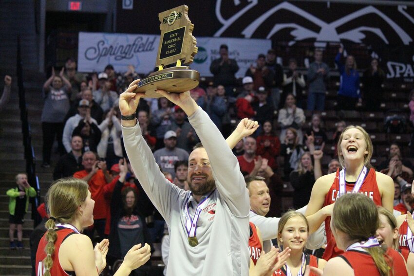 Tipton athletic director and girls basketball head coach Jason Culpepper holds up the Class 2 State Championship trophy after winning the title game on March 11, 2023. The Cardinals' school board voted Wednesday to join a new eight-team athletic conference beginning in 2024-25.&nbsp;   PhotoCredit: File photo by Bryan Everson | Democrat