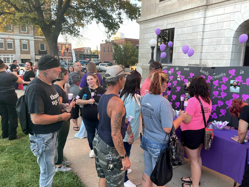 Those remembering loved ones write notes for a display board for the International Overdose Awareness Day event hosted by Recovery Lighthouse on Thursday, Aug. 31 outside the Pettis County Courthouse. A candlelight vigil and walk to City Hall followed speakers in substance abuse and recovery.   Photo by Chris Howell | Democrat