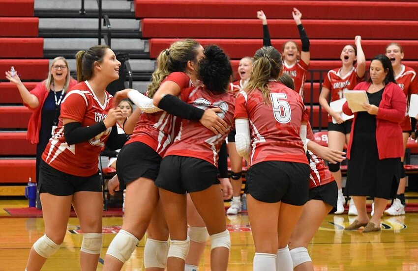 Sacred Heart volleyball teammates celebrate on the court and from the bench as part of Monday's victory over Marshall in the team's home opener.   PhotoCredit: Photo courtesy of Sacred Heart volleyball