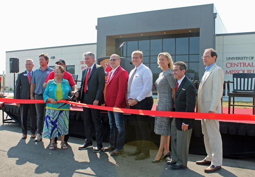 State officials and University of Central Missouri representatives celebrate the opening of the University of Central Missouri's new Skyhaven Aviation Center with a ribbon cutting Friday afternoon, Sept. 8. From left, David Pearce, UCM executive director for governmental relations; Scott Fitzpatrick, Missouri state auditor; Warrensburg residents Lynn and Jackie Harmon; Roger Best, university president; state Sen. Denny Hoskins, Missouri District 21; Tyler Young, senior professional pilot student from Troy; Courtney Goddard, vice president for advancement and executive director of the UCM Alumni Foundation; Mark Suazo, dean of the Harmon College of Business and Professional Studies; and Ed Hassinger, Missouri Department of Transportation deputy director and chief engineer.   Photos by Nicole Cooke | Warrensburg Star-Journal