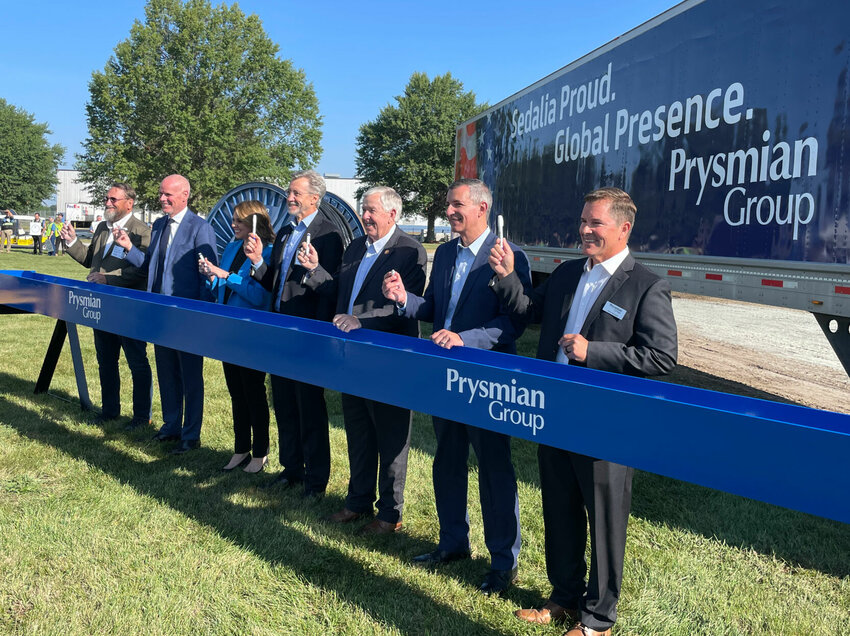 Prysmian Group hosted a beam signing ceremony Wednesday morning, Sept. 13 at its Sedalia plant. From left, Pettis County Presiding Commissioner Bill Taylor, Prysmian Senior Vice President Brian Moriarty, Missouri Department of Economic Development Acting Director Michelle Hataway, Prysmian CEO Andrea Pirondini, Gov. Mike Parson, Prysmian COO Paul Furtado and Sedalia Plant Manager Steve Simonic prepare to sign.   Photo by Chris Howell | Democrat
