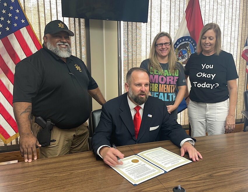 Pettis County Sheriff's Office Community Interaction Deputy Larry Parham, Mayor Andrew Dawson, professional counselor Brin Spanhorst, and DeFeet board member Robin Balke gather as Dawson proclaims September as Suicide Prevention Month in Sedalia.   Photo by Chris Howell | Democrat