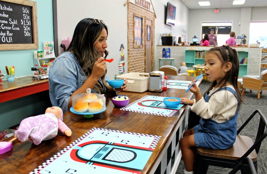 Melanie Morales and her daughter, 2-year-old Camila Rodriguez, enjoy some &quot;lunch&quot; at Ema's Diner while visiting My Little Town on opening day Monday, Sept. 25. Morales, of Whiteman Air Force Base, said they are originally from Chicago, where businesses like My Little Town are common, so she was excited to hear about the new offering in Warrensburg. She said they were having a lot of fun, and Rodriguez especially liked all the stuffed animals at the vet's office.   Photo by Nicole Cooke | Warrensburg Star-Journal
