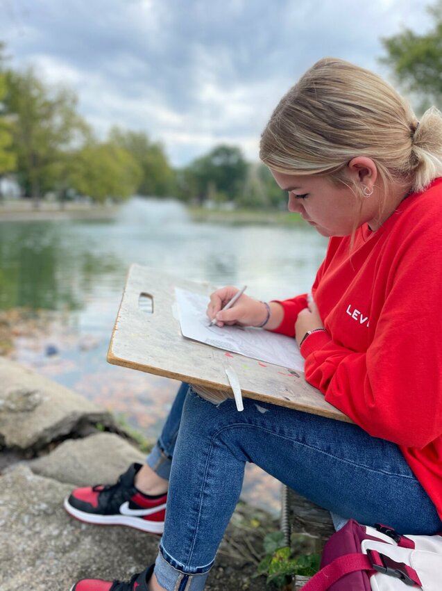 Lincoln sophomore Delaney Monteer sketches by the Liberty Park pond Wednesday, Oct. 4 as students from the Kaysinger Conference compete in the friendly competition.   Photo by Chris Howell | Democrat