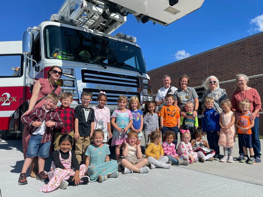 Preschoolers at the Loftus Early Childhood Center got a visit from the Sedalia Fire Department on Wednesday, Oct. 11. Students, teachers, staff and Battalion Chief Barry White posed for a group photo with the fire truck SFD brought to the school.   Photo by Chris Howell | Democrat