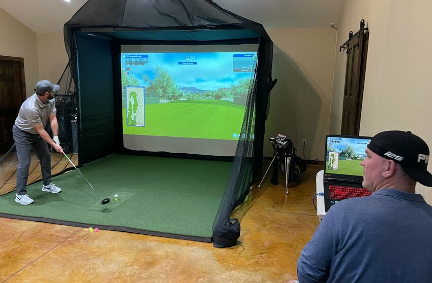 Steve Goldacker takes a swing on one of the 10,000 golf courses available for play at Down Range Indoor Golf Simulator on Thursday, Nov. 16. Owner Andy Williams operates the simulator.   Photo by Chris Howell | Democrat