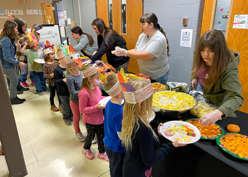 As teachers guide kindergarten students through the line, parent volunteers help serve up snacks for a Thanksgiving feast on Tuesday afternoon, Nov. 21 at Skyline Elementary.&nbsp;   Photo by Nicole Cooke | Democrat