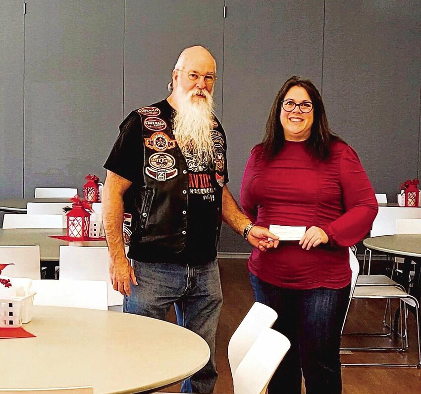 Frank Rouchka, Central Missouri Sedalia Harley Owners Group treasurer, presents a $450 check to Leslee Howard, Center Coordinator for the Sedalia Senior Center/Care Connections for Aging Services.   Photo courtesy of Central Missouri Sedalia Harley Owners Group
