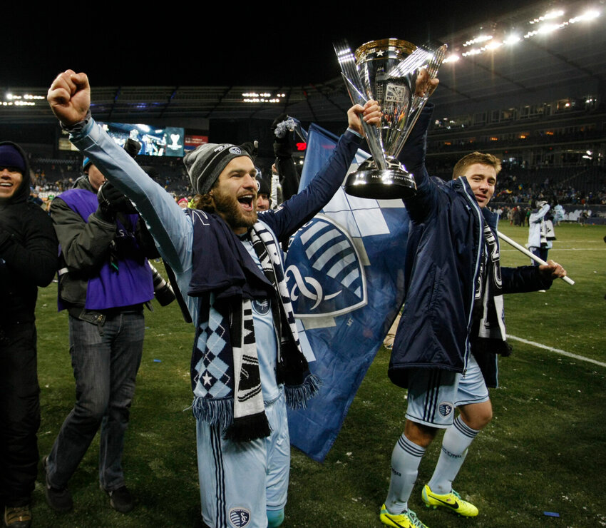 Sporting Kansas City's Graham Zusi, left, and Matt Besler, right, celebrate as they carry the MLS Cup after their 2-1 win over Real Salt Lake in the MLS Cup soccer final match in Kansas City, Kan., Saturday, Dec. 7, 2013.   PhotoCredit: File photo by Colin E. Braley | AP Photo
