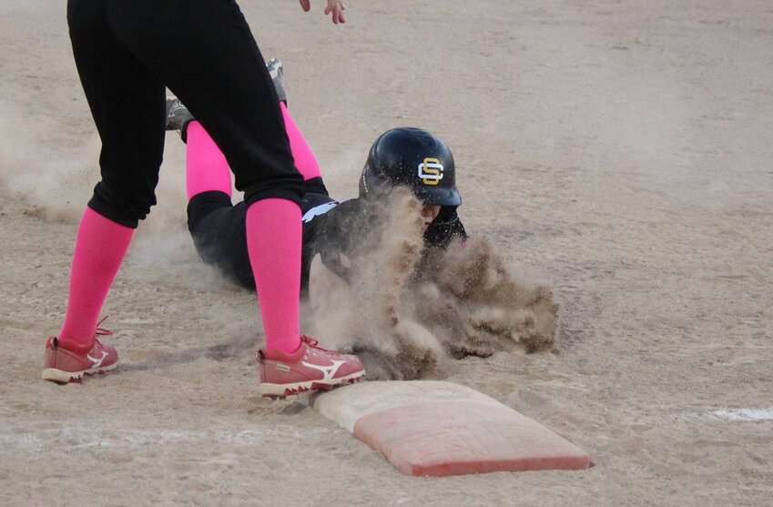 Smith-Cotton's Ellie Kimbrough kicks up dust while diving back to first base in Thursday night's 6-3 victory over Marshall on Pink Out Night.   PhotoCredit: Photo by Bryan Everson | Democrat