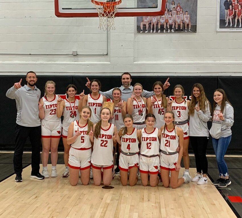 The Lady Cardinals celebrate with the first-place trophy Friday night after beating California in the title game of their namesake tournament. Tipton improved to 4-0 over the course of the tourney.   PhotoCredit: Photo courtesy of Tipton Lady Cardinals