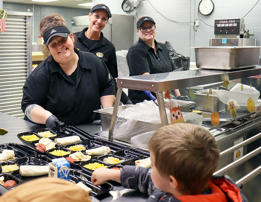Skyline Elementary School Food Service workers, from left, Kim Paul, Carianne Chappell and Danielle Edwards serve lunch to kindergarten students in the school's cafeteria. A new menu this school year has prompted an increase in meals served.   Photo courtesy of Sedalia School District 200