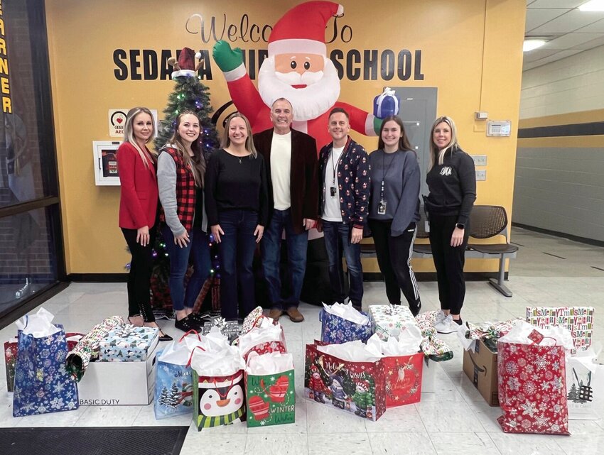 Pettis County Real Estate Company partnered with the Sedalia Middle School to adopt students for Christmas this year. Dropping off the donations, from left, are Nadia Fray, Allison Kroeger, Kelly and Myron McNeal from Pettis County Real Estate Company, SMS Principal Jeremy Fry, math teacher Kasey Miller, and social worker Dana White. Not pictured are Sadie Reeser of Pettis County Real Estate and social worker Maria Matacua.   Photo courtesy of Pettis County Real Estate