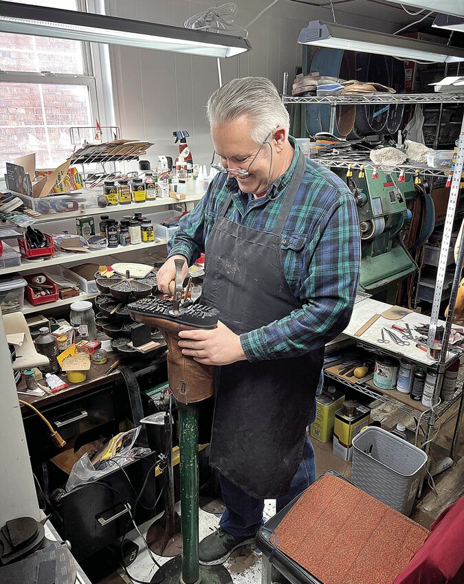 Thursday morning, Jan. 11, Eduard Dudkin demonstrates how he resoles a boot in his shop, Master Shoe Repair, 420B S. Osage Ave. Eduard and his wife, Maryna Dudkina, opened the full-service shop in March 2022.   Photo by Faith Bemiss-McKinney | Democrat
