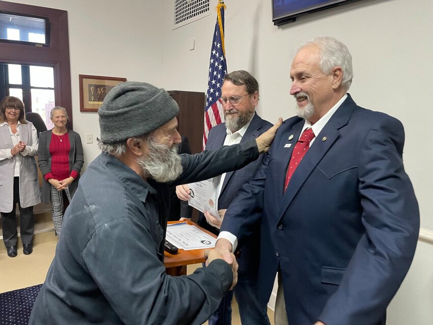Forty-year Pettis County employee Hollis Bell, with the Pettis County Road and Bridge Department, left, shakes hands with Western Commissioner Jim Marcum on Friday, Jan. 19 in the commission chambers at the Pettis County Courthouse. Marcum received his own 10-year service award from the county.   Photo by Chris Howell | Democrat