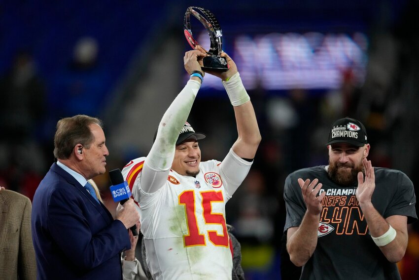 Kansas City Chiefs quarterback Patrick Mahomes (15) holds up the Lamar Hunt Trophy after the AFC Championship NFL football game against the Baltimore Ravens, Sunday, Jan. 28, 2024, in Baltimore. The Chiefs won 17-10. Kansas City Chiefs tight end Travis Kelce stands at right.   PhotoCredit: Photo by Nick Wass | AP Photo