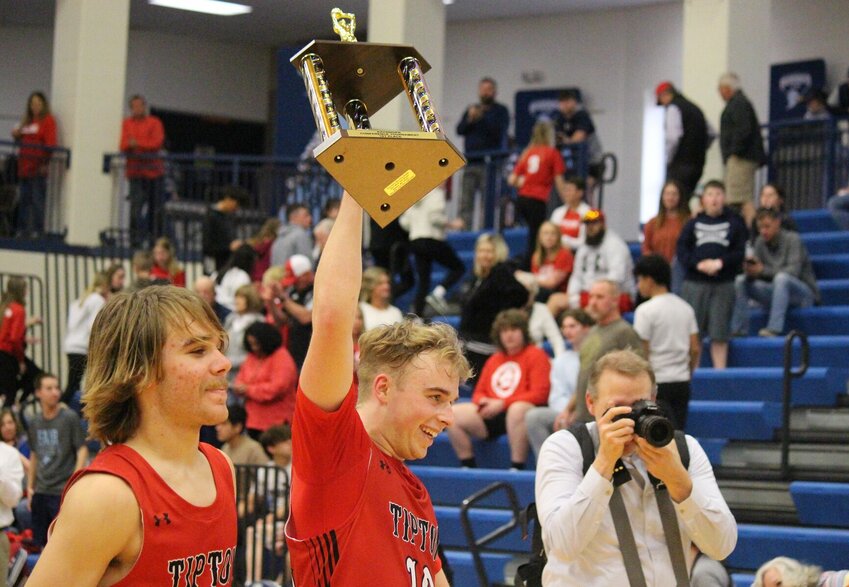 Tipton senior Jackson Bailey hoists the Kaysinger Conference Boys Tournament first-place trophy after Saturday's victory over Sacred Heart at State Fair Community College.   PhotoCredit: Photo by Bryan Everson | Democrat
