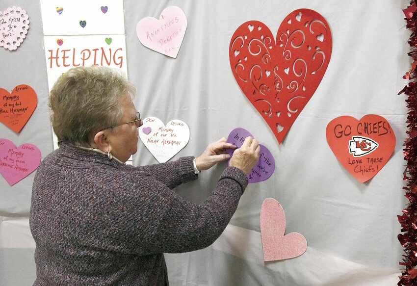 Monday morning, Feb. 5, Marilyn Grechus, vice president of Church Women United, places a memorial heart on the Helping Hands display at the Pettis County Public Administrator's Office. Each February, Public Administrator Charli Ackerman collects donations for clients in the program. CWU donated to the cause on Monday, Feb. 5.   Photo by Faith Bemiss-McKinney | Democrat