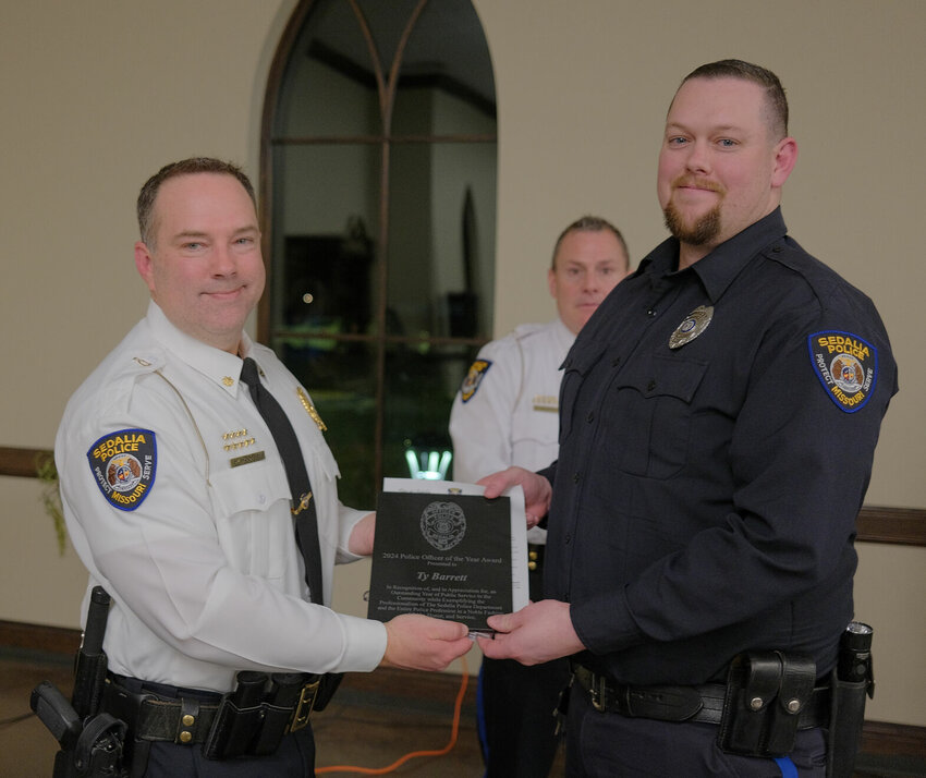 At Tuesday's Sedalia Police Awards Ceremony, Interim Chief David Woolery presents Detective Ty Barrett with the 2024 Officer of the Year Award. Barrett is team leader with the Special Response Team and often serves as &quot;breacher.&quot;   Photo by Chris Howell | Democrat