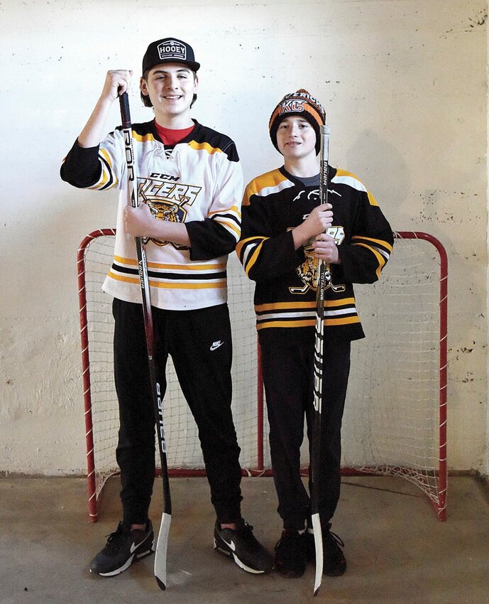 Tyson Carnes, left, and Colton Rippey, both 13, pose for a photo on Monday, Feb. 12 at Rippey's house. The young men play ice hockey with the Mid-Missouri Tigers hockey team, which competes in Jefferson City at the Washington Park Ice Arena. They and their parents hope to inspire local interest in the sport.   Photo by Faith Bemiss-McKinney | Democrat