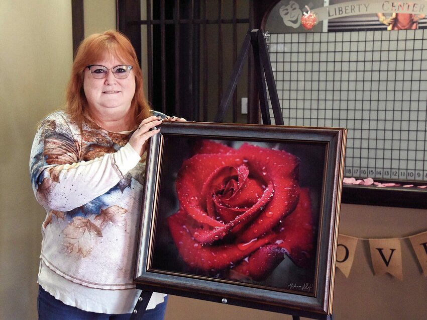 On Saturday, Feb. 17, Sedalia photographer Melissa Alexander stands beside her photo of a red rose that won an honorable mention at the 2022 Missouri State Fair. Alexander was the Artist-in-Residence for the Liberty Center Association for the Arts on Saturday.   Photo by Faith Bemiss-McKinney | Democrat