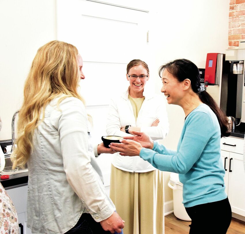 On Wednesday, Feb. 21, upstairs at Ozark Coffee Co., award-winning barista Phuong Tran, right, shares a laugh with Ashley Homan, a pop-up coffee shop owner. Tran, the director of coffee education for Brewed Behavior in Kansas City, gave a two-day workshop for the staff of Ozark Coffee and its wholesale customers.&nbsp;   Photo by Faith Bemiss-McKinney | Democrat