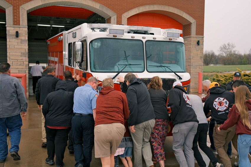 Citizens, Sedalia officials and firemen join forces to push Sedalia's newest fire truck into its bay at the 16th Street Fire Headquarters on Monday, March 25.   Photo by Chris Howell | Democrat