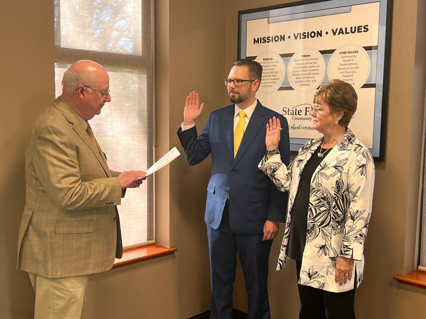 From left, State Fair Community College Board of Trustees member Richard Parker swears in Jeff Page and Patty Wood during the board meeting Thursday, April 11. Page is a new member of the board, while Wood has served since 2012.