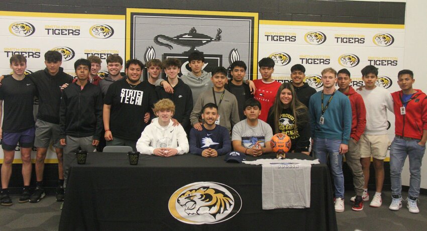 Smith-Cotton seniors, sitting from left, Tyler Baur, Mario Rojas and Juan Pascual celebrate signing their letters of intent to State Fair Community College with the rest of the Tigers boys soccer team.   Photo by Jack Denebeim | Democrat